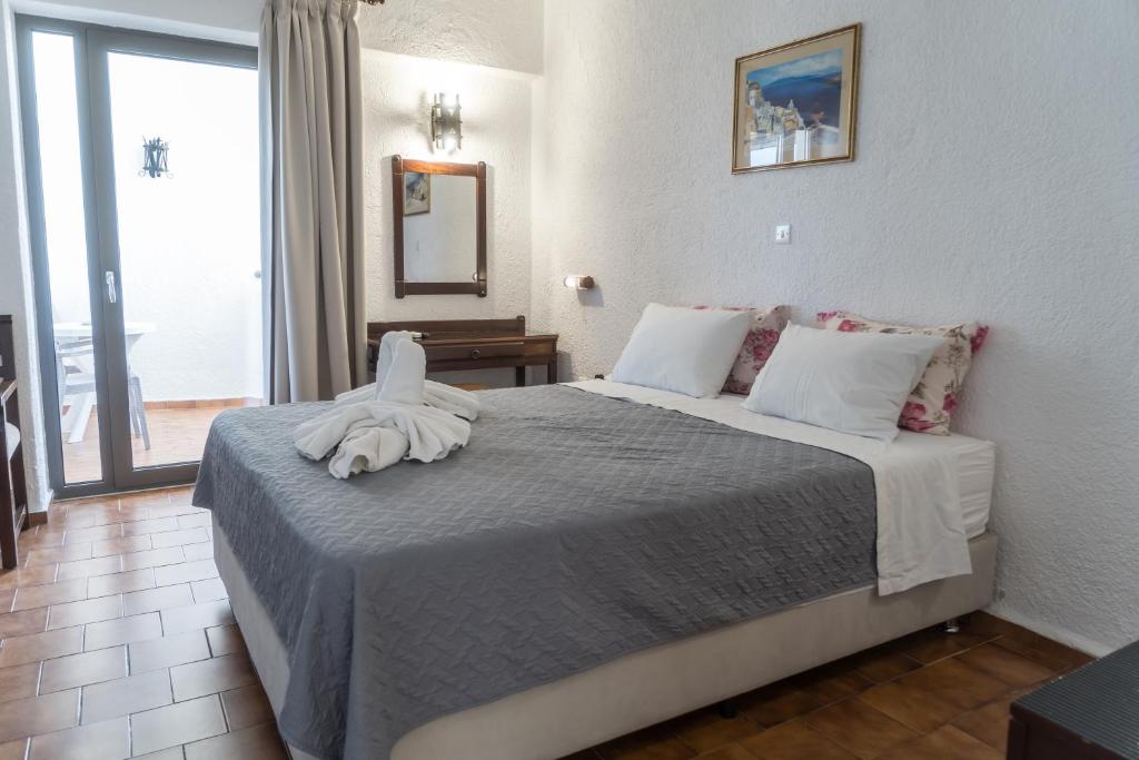 Mūsdienīga guļamistaba ar divguļamo gultu, dekorētu ar spilveniem un dvieļiem, kā arī piekļuvi balkoniem. Telpai ir gaiša krāsu shēma un koka grīdas segums.