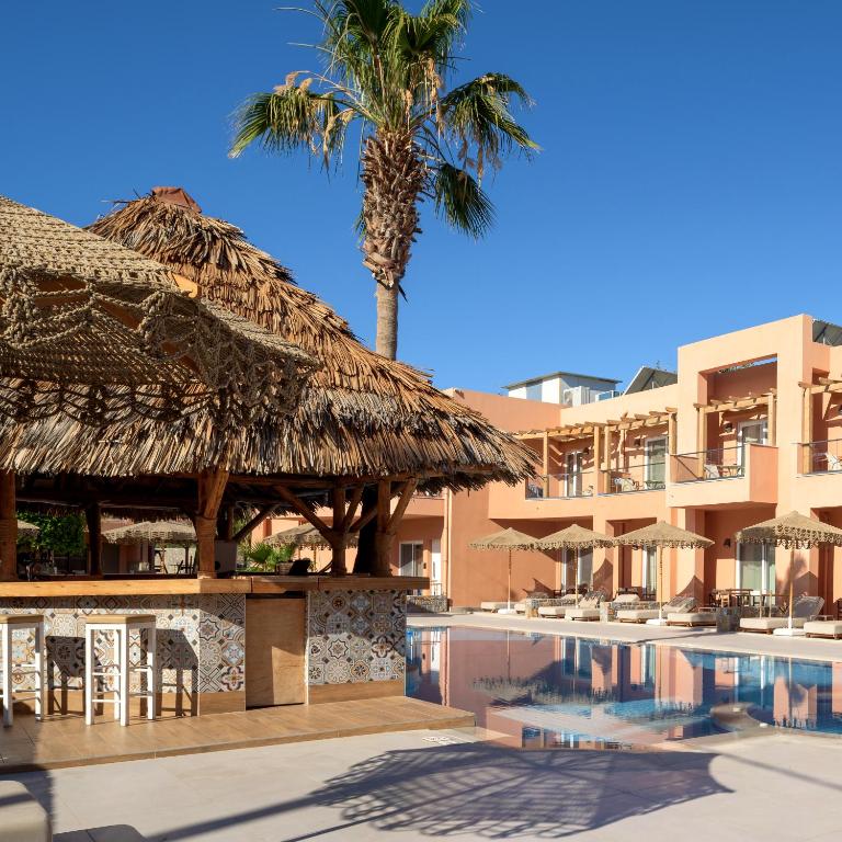 Tropu stila bārs blakus peldbaseinam, ar palmu fona un modernām viesnīcas ēkām. Ideāla vieta relaksācijai un atpūtai.