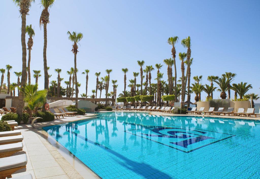 Saule spīd pie baseina The GrandResort Limassol Cyprus