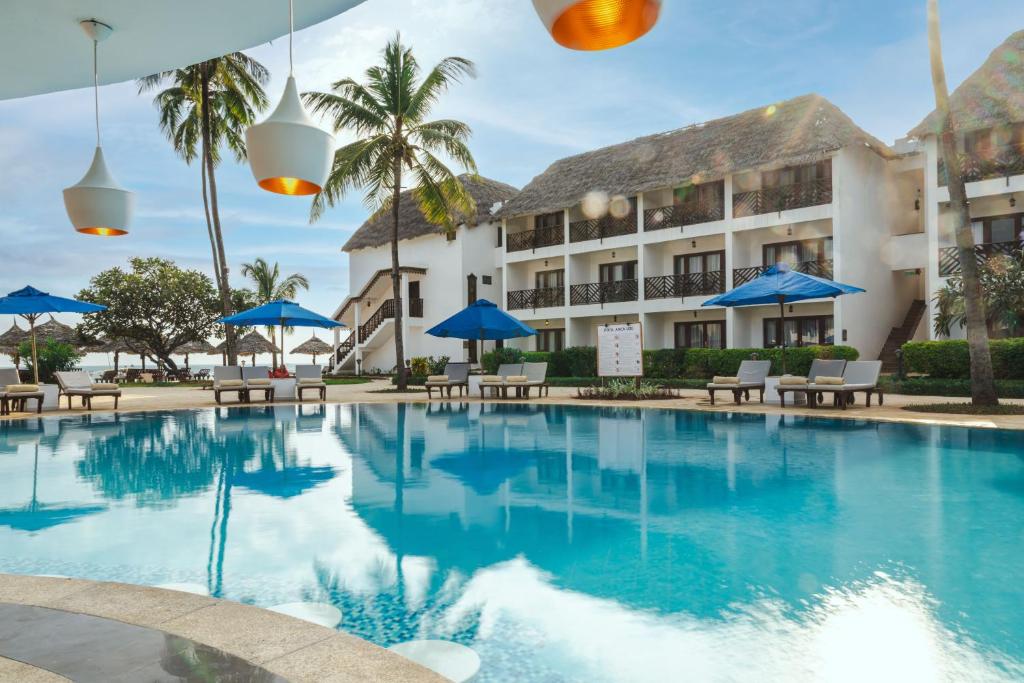 Nungwi Beach Resort by Turaco baseins ar skatu uz ēku un palmu kokiem