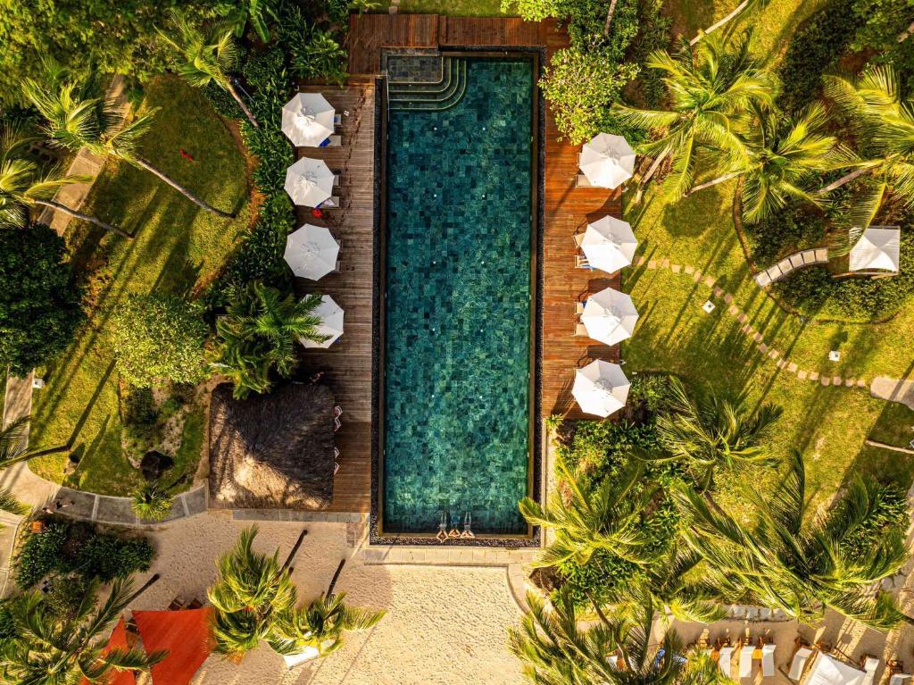Skats uz Hilton Mauritius Resort & Spa baseinu un dārziem no augšas.