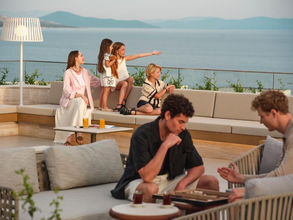 Viesi relaksējas pie Anda Barut Collection terases ar skatu uz jūru.