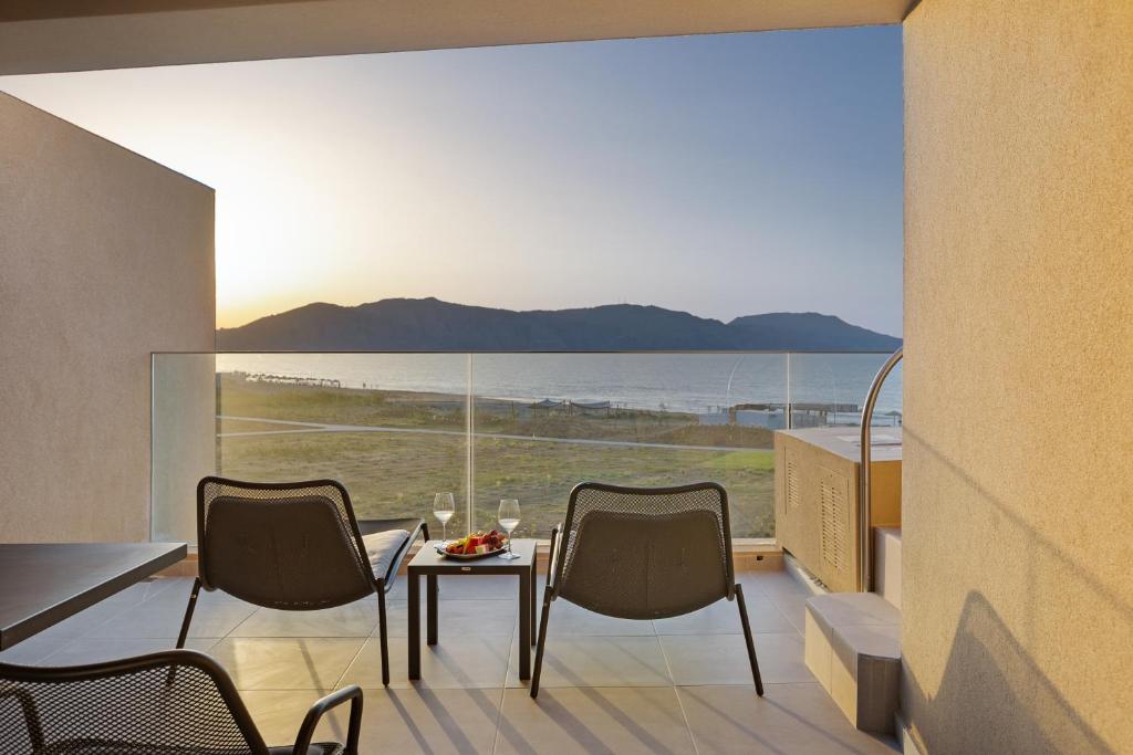 Balkons ar skatu uz jūru un kalniem, divas krēsli un galds ar augļiem un dzērieniem. Ideāla vieta relaksācijai un saulrieta baudīšanai.