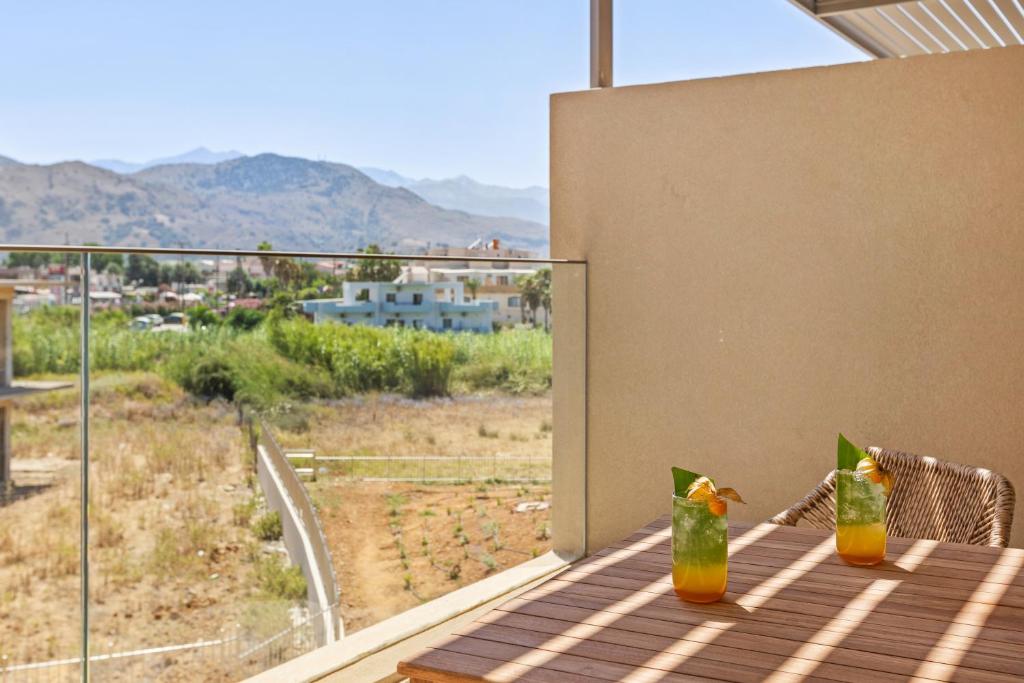 Balkona skats uz kalniem ar divām dzērienu glāzēm uz koka galda. Ideāla vieta relaksācijai un atpūtai.