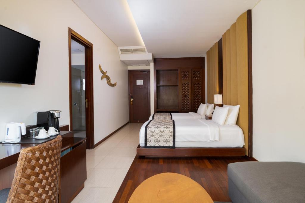 Mūsdienīgs viesnīcas numurs ar divām gultām, televizoru, galdu un krēslu, kā arī kafejnīcas stūri. Interjers ir elegants ar siltām krāsām un koka akcentiem.