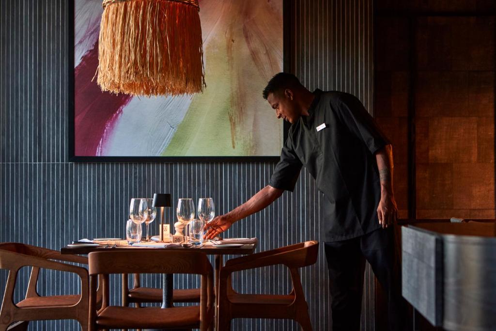 Viesmīlis uzliek galdu restorānā RIU Turquoise Mauritius.