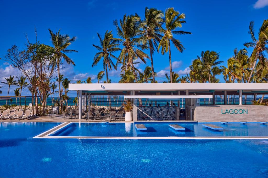 Baseins pie viesnīcas RIU Turquoise Mauritius ar palmām un bāru.