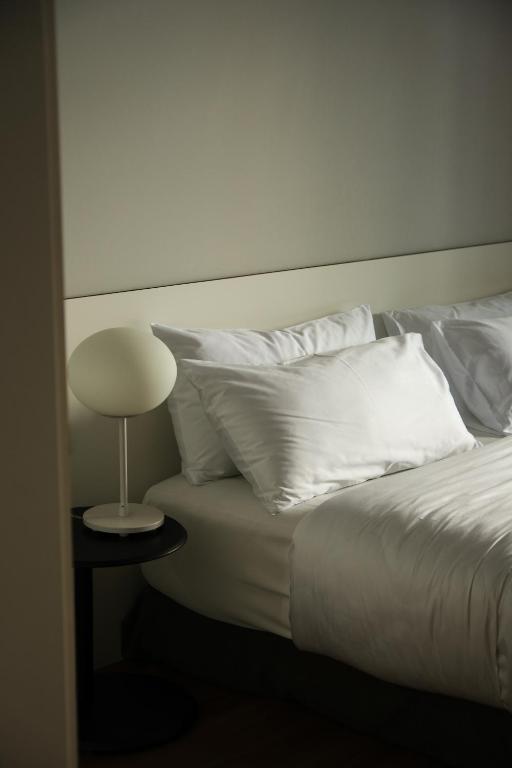 Mūsdienīgs guļamistabas stūris ar ērtiem spilveniem un stilīgu galda lampu. Ideāla vieta relaksācijai un atpūtai.