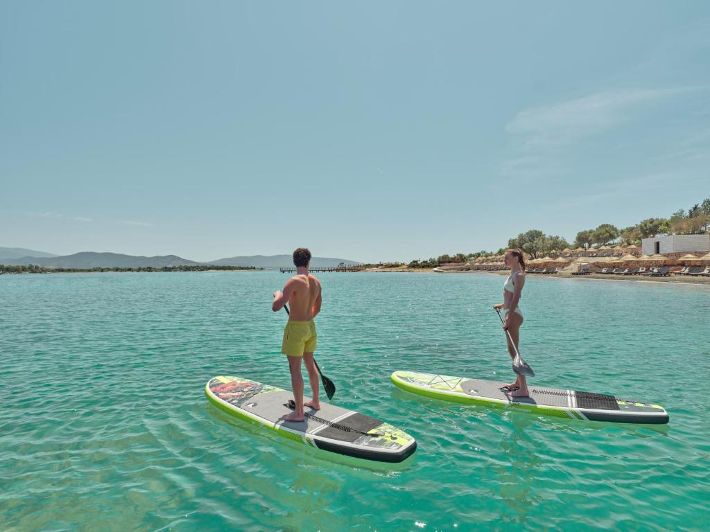 Divi cilvēki, kas nodarbojas ar SUP piekrastē, Anda Barut Collection.