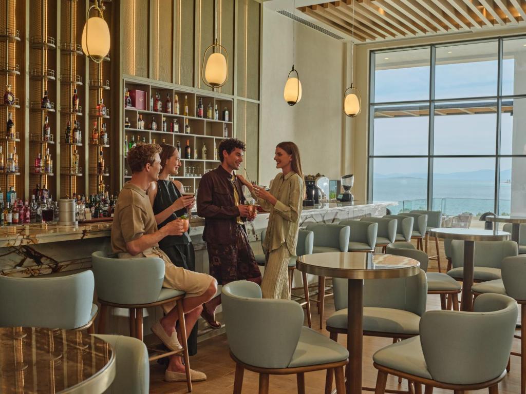 Bārs piekrastē ar viesiem, kas izbauda dzērienus, Anda Barut Collection