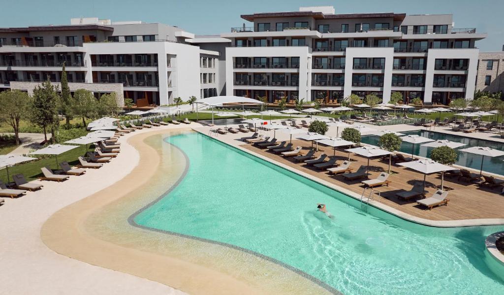 Viesnīca Anda Barut Collection ar elegantu baseinu un saulessargiem piekrastē.