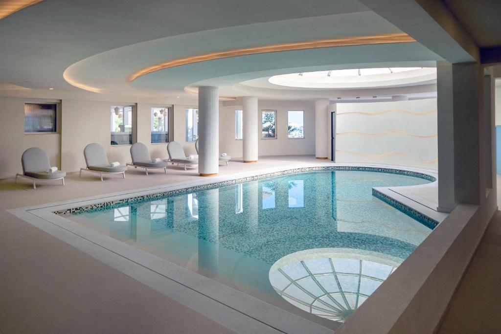 Elegantā peldbaseina ar mīkstām atpūtas krēslām un dabīgu apgaismojumu, radot relaksējošu atmosfēru. Ideāla vieta atpūtai un komfortam.