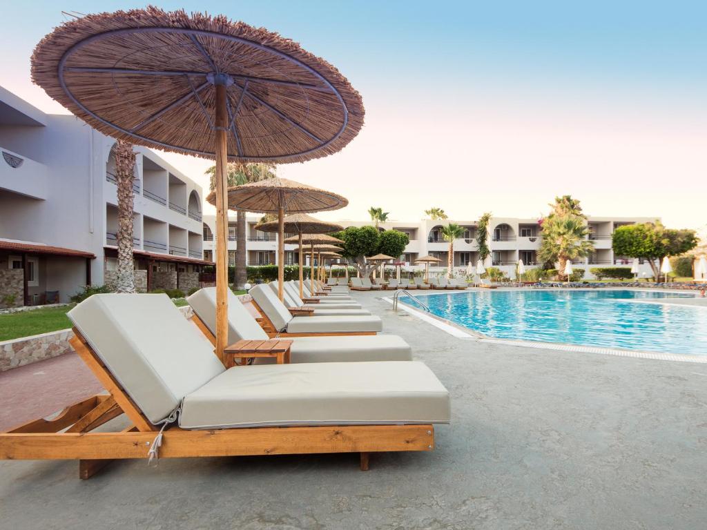 Pludmales gultas pie Lardos Bay viesnīcas baseina.