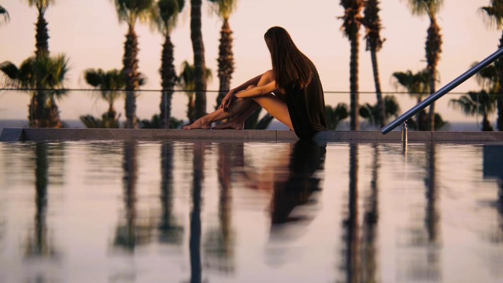 Sieviete pie baseina viesnīcā The GrandResort Limassol Cyprus