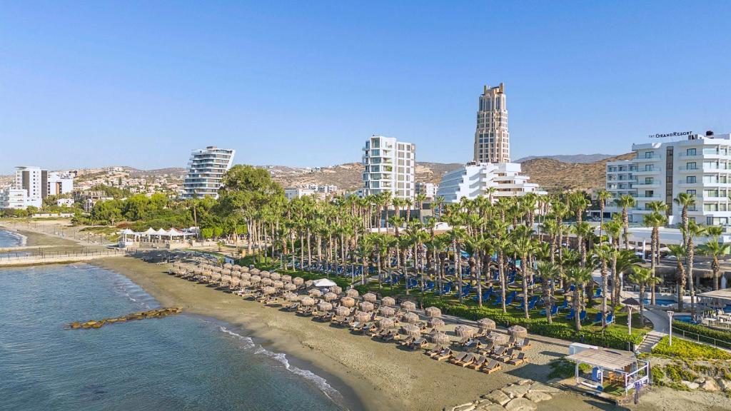 The GrandResort Limassol Cyprus piekrastē ar palmu aleju un pludmali.
