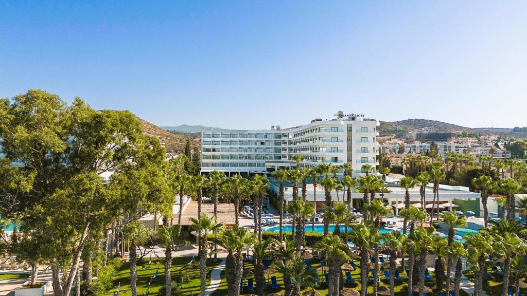 The GrandResort Limassol Cyprus piekrastē ar palmu ieskautu baseinu