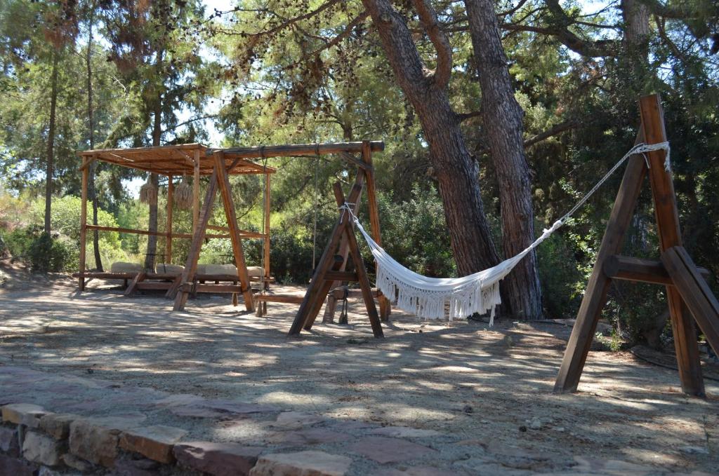 Atpūtas zona ar šūpuļtīkliem pie Cook's Club Ialysos Rhodes, apzaļumotā vidē.