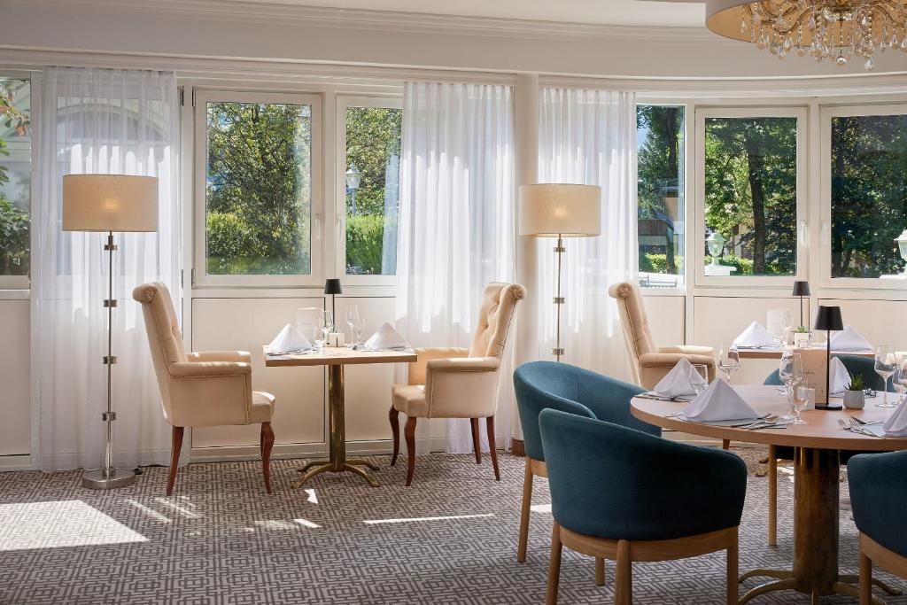 Eleganta restorāna interjers ar gaišiem logiem, stilīgām mēbelēm un skaistu apgaismojumu. Telpa ir piepildīta ar dabīgu gaismu un rada patīkamu atmosfēru.