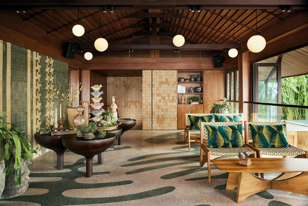 Mūsdienīgs interjers ar dabīgiem elementiem, stilīgām mēbelēm un zaļām akcentiem, kas rada relaksējošu atmosfēru. Ideāla vieta atpūtai un iedvesmai.