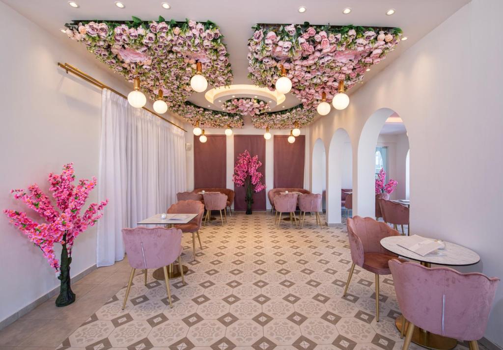 Elegants interjers ar rozā ziedu dekori un gaismas ķermeņiem, radot mājīgu atmosfēru. Rūpīgi izvēlēti mēbeļu elementi un flīžu grīda papildina kopējo estētiku.