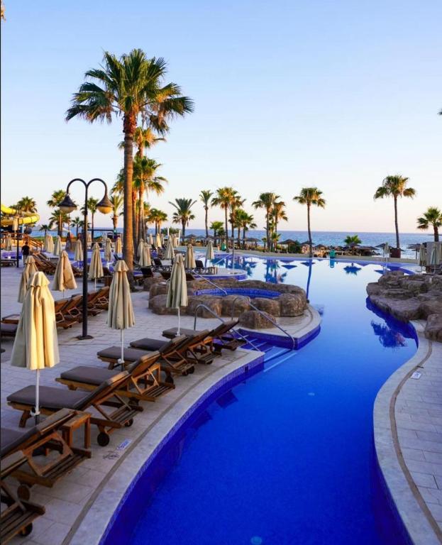 Adams Beach baseins pie palmu koku un jūras krasta