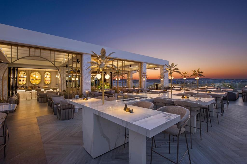 Adams Beach jumta terase ar skatu uz saulrietu