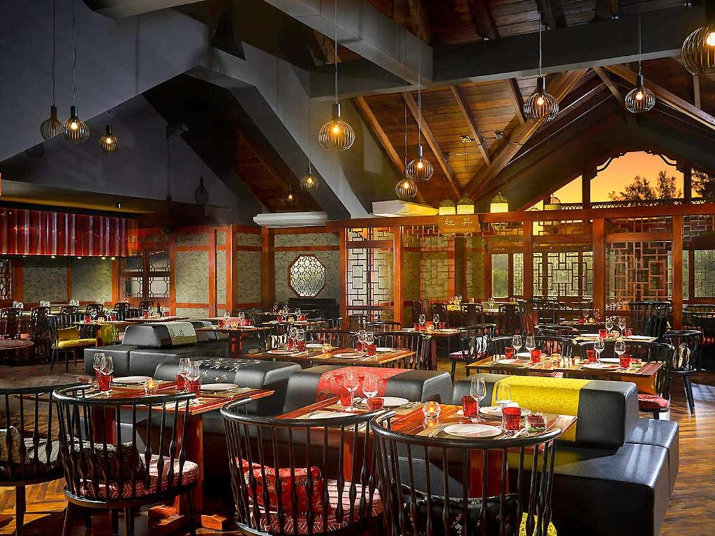 Elegants restorāns ar modernu interjeru, kurā apvienotas tradicionālas un mūsdienīgas detaļas. Apgaismojums un koka elementi rada siltu un aicinošu atmosfēru.