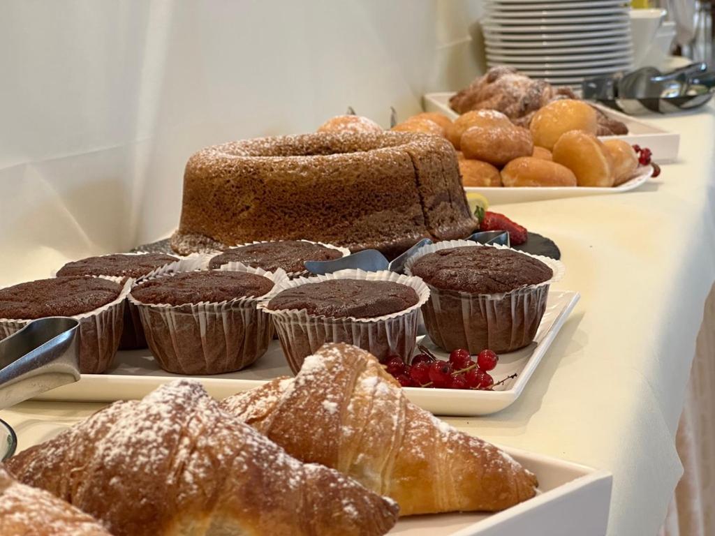 Deserts ar šokolādes kūkām, cepumiem un kruasāniem, kas izkārtoti uz galda. Saldumi dekorēti ar pūdercukuru un svaigiem augļiem.