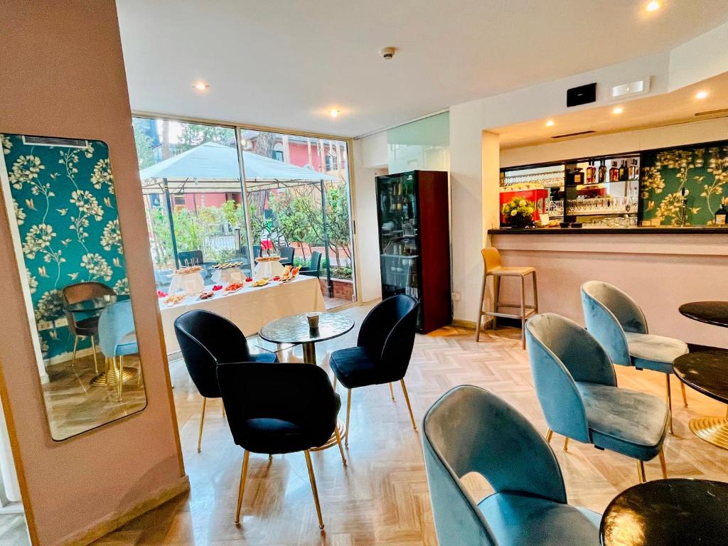 Mūsdienīgs bārs ar elegantiem krēsliem un galdiem, kurā redzama dabiska gaisma un dārza skats caur logiem. Interjers ir dekorēts ar ziedu motīviem un piedāvā dažādus dzērienus.