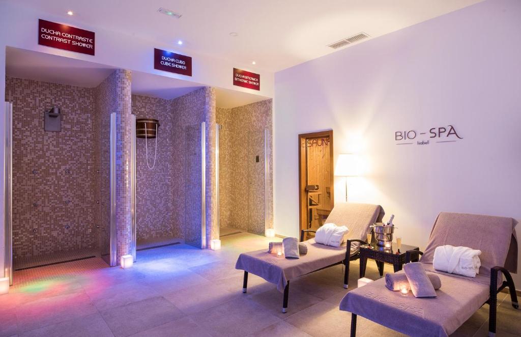 Relaksējošs spa interjers ar dažādiem dušas veidiem un atpūtas zonu, kurā ir šūpuļkrēsli un gaismas efekti. Ideāla vieta relaksācijai un labsajūtai.