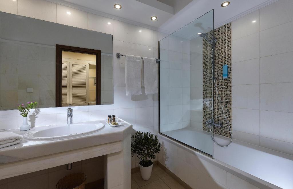Moderna vannas istaba viesnīcā Alexander Beach Hotel & Village ar stikla dušu.