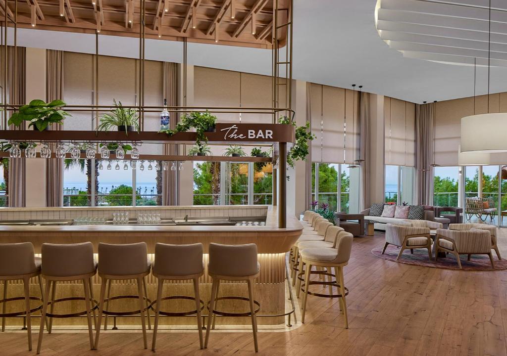 Moderns bārs ar elegantiem krēsliem un skatu uz dārzu piekrastē hotelī Akra Sorgun Tui Blue Sensatori.