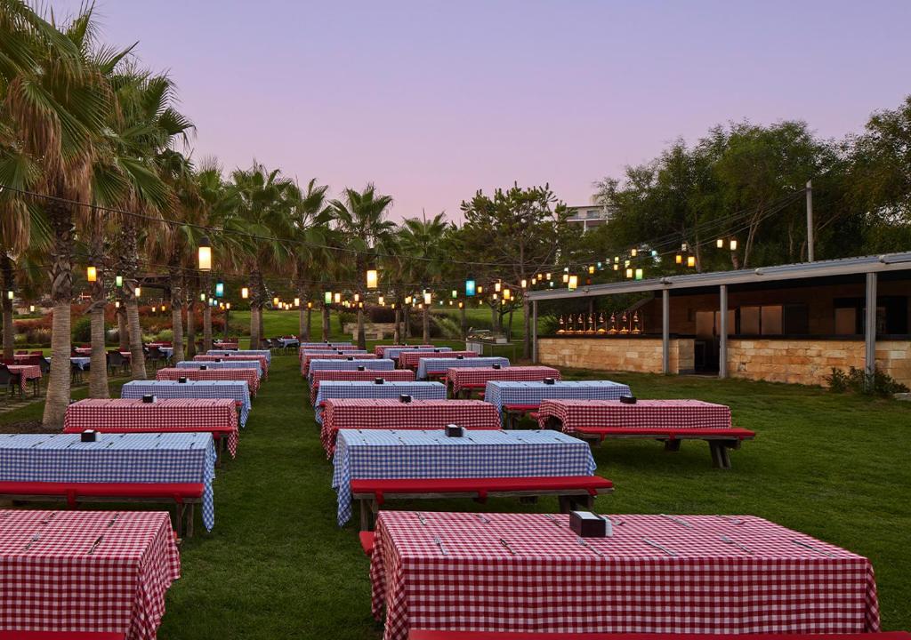 Āra restorāns ar galdiem pie Akra Sorgun Tui Blue Sensatori, apgaismots ar laternām.