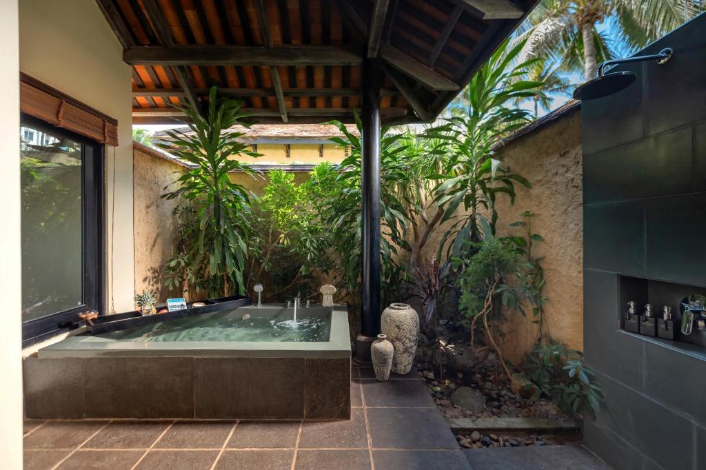 Āra vannas istaba ar džakuzi, ko ieskauj zaļumi un tropiskās augi, radot mierīgu un relaksējošu atmosfēru. Ideāla vieta atpūtai un relaksācijai.