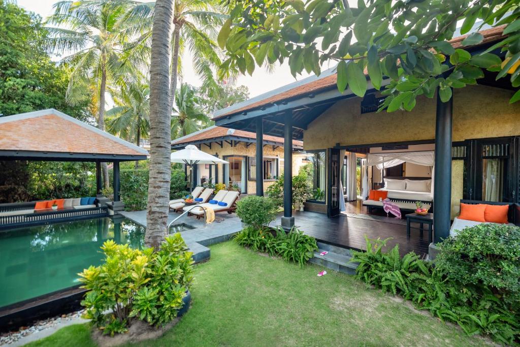 Tropiska brīvdienu māja ar privātu baseinu, dārzu un palmām. Mūsdienīgs dizains un ērti atpūtas stūri ārpusē.