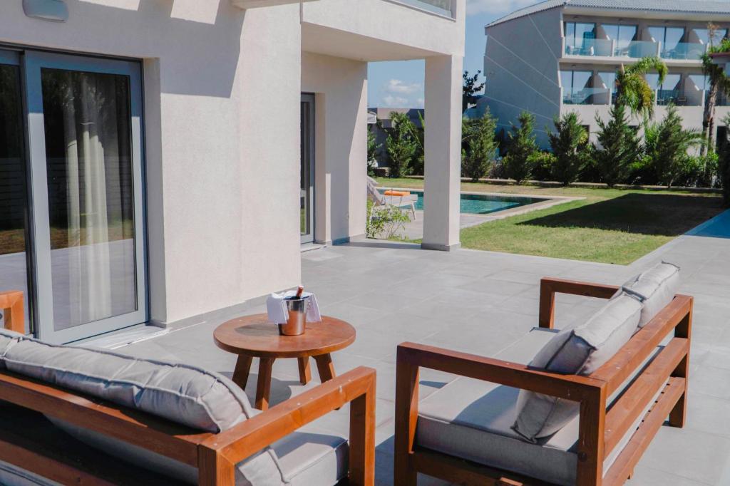 Terase ar koka mēbelēm pie Princess Sun Hotel, blakus baseinam.