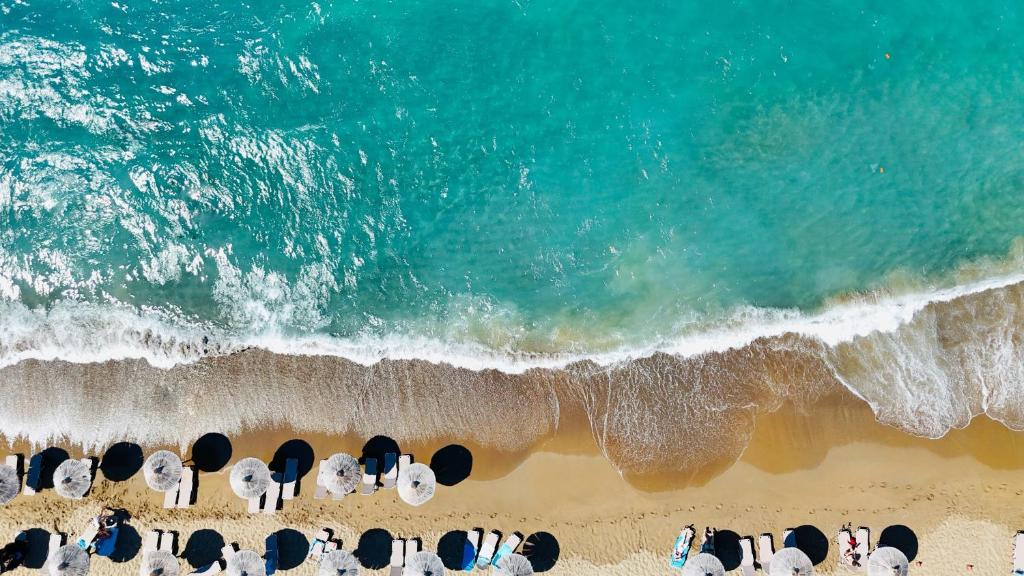 Pludmale ar saulessargiem un skaidru zilo ūdeni, viļņi krīt krastā. Ideāla vieta atpūtai un relaksācijai.