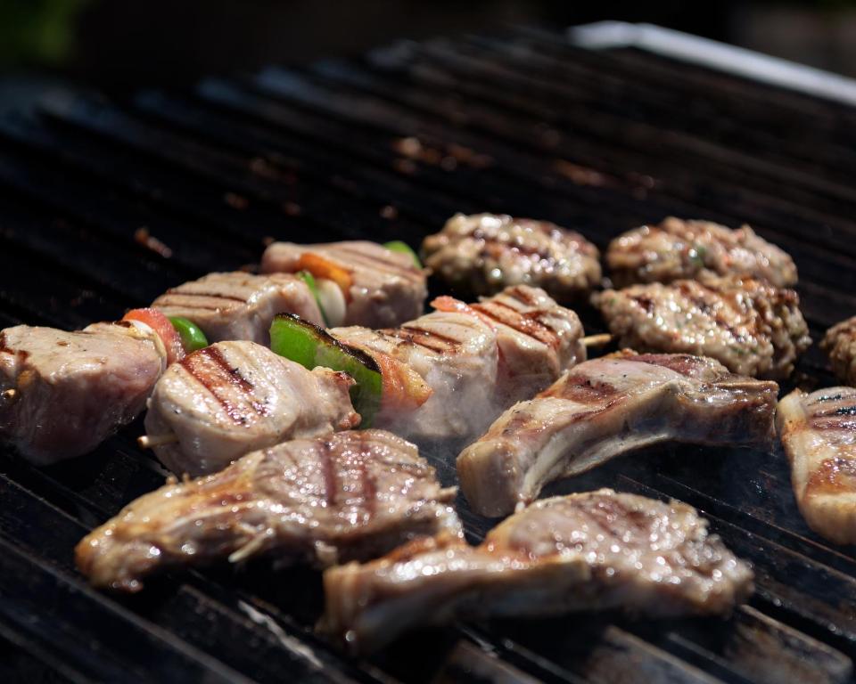 Grilēti gaļas gabali ar dārzeņiem, kas sacepti uz grila, radot siltu un garšīgu maltīti.