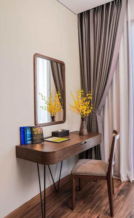 Vipol Muine Hotel & Spa elegant desk area with mirror and flowers.