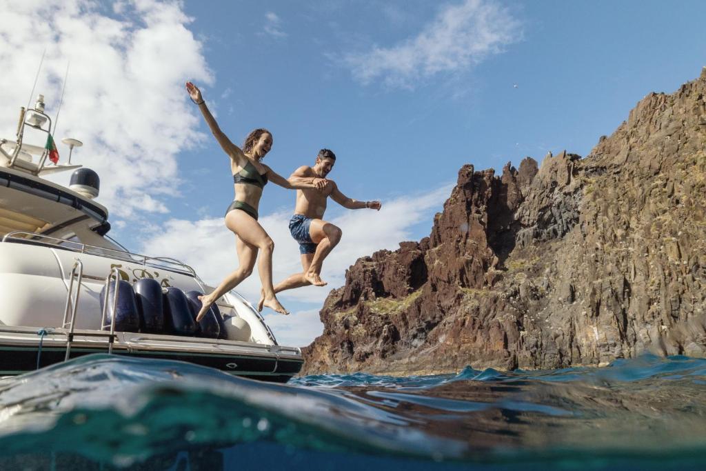 Pāris lēkā no jahtas ūdenī pie Dreams Madeira Resort Spa & Marina.