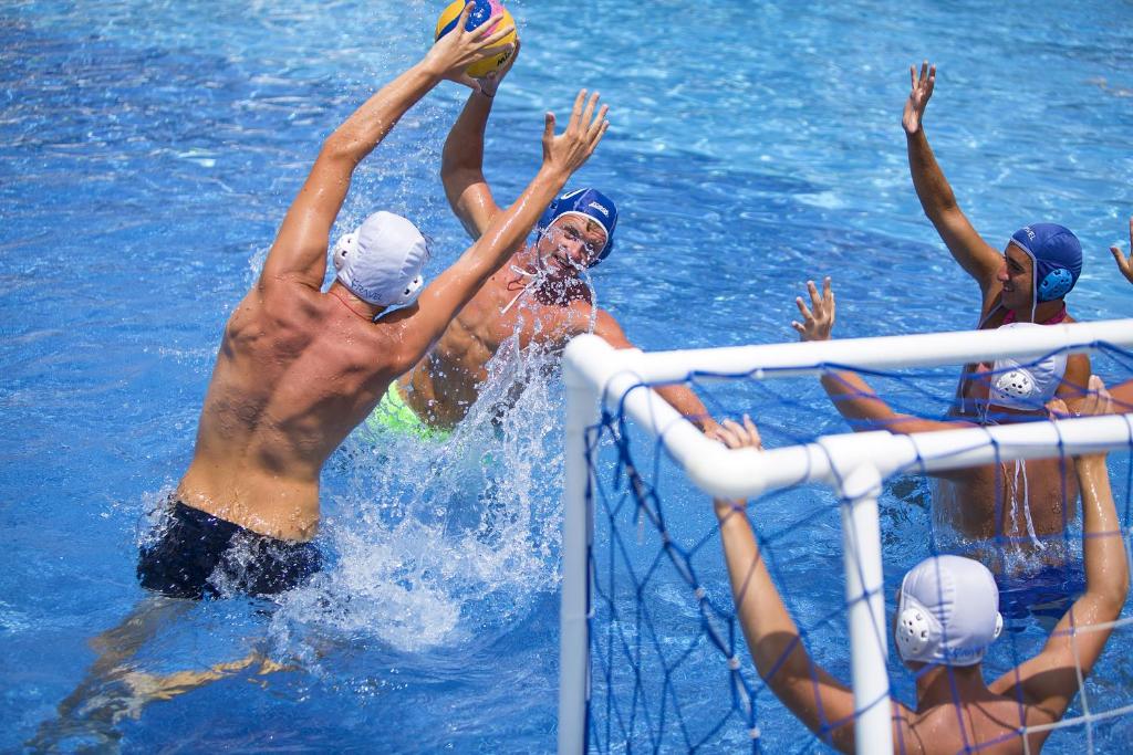 Vīrieši spēlē ūdenspolu Bellis Deluxe Hotel baseinā.