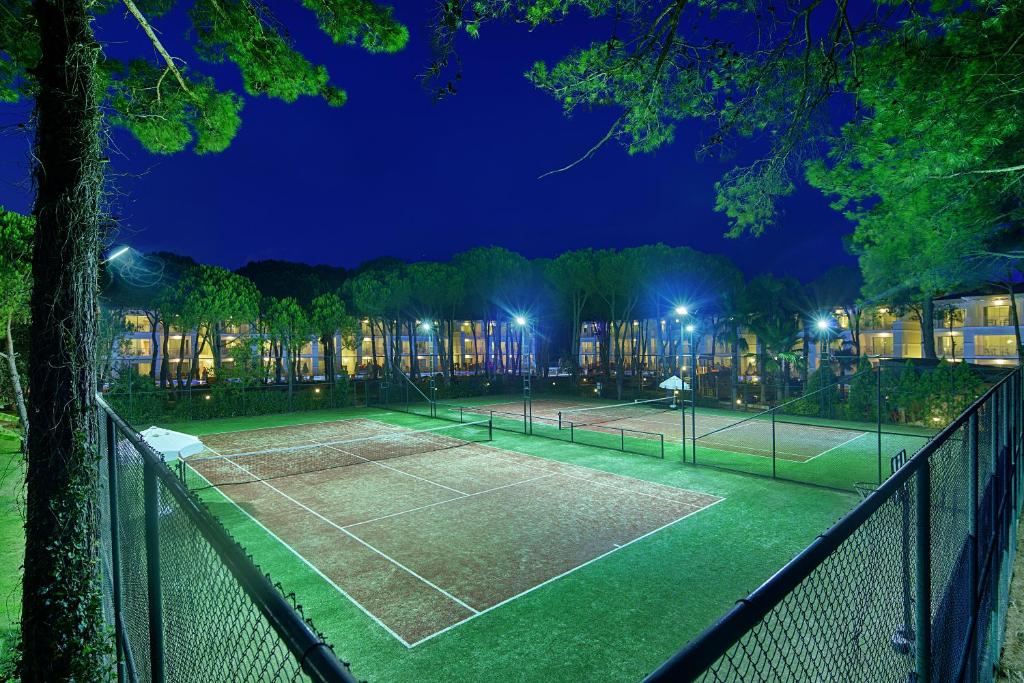 Tennis courts illuminated at night at Bellis Deluxe Hotel.