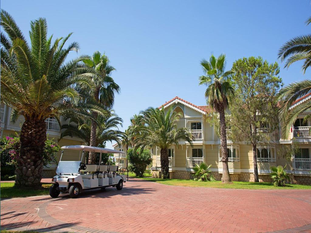 Gural Premier Belek viesnīca ar palmām un golfa ratiņiem