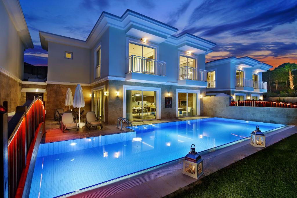 Bellis Deluxe Hotel pievilcīgs baseins ar numuriem un saulrietu.