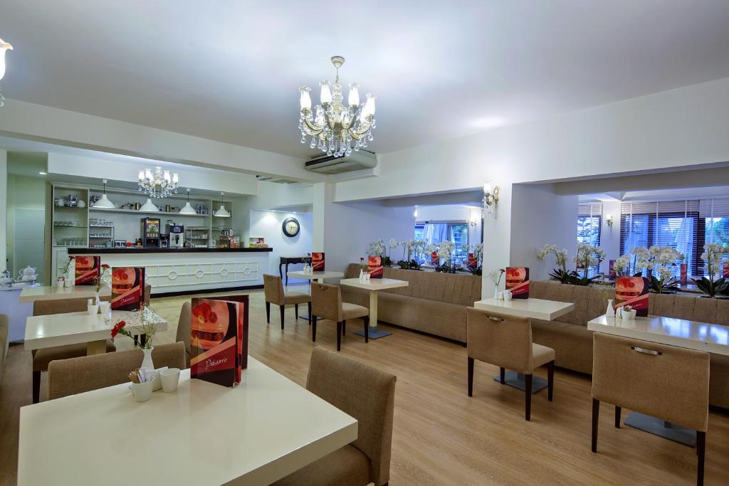 Gaišs un elegants restorāns Bellis Deluxe Hotel ar modernām mēbelēm.