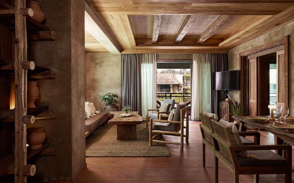 Mūsdienīga viesistaba ar koka elementiem, siltām krāsām un dabīgiem materiāliem, kas rada mājīgu atmosfēru. Telpā ir dabiski apgaismojums un ērti mēbeļu izkārtojumi.