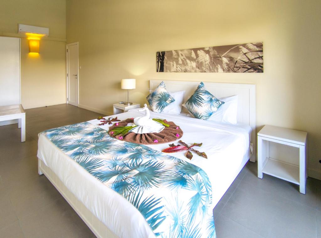 Be Cosy Apart Hotel numurs ar ziedu dekorācijām uz gultas.