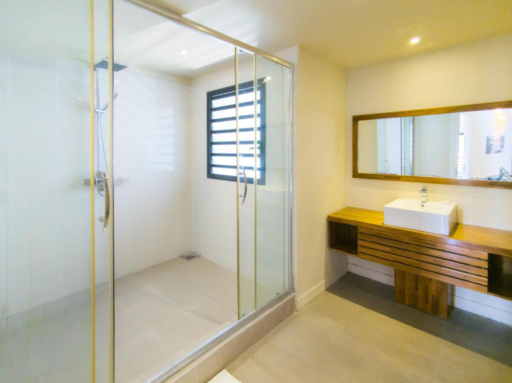 Mūsdienīgs vannas istabas numurs Be Cosy Apart Hotel ar stikla dušas kabīni.