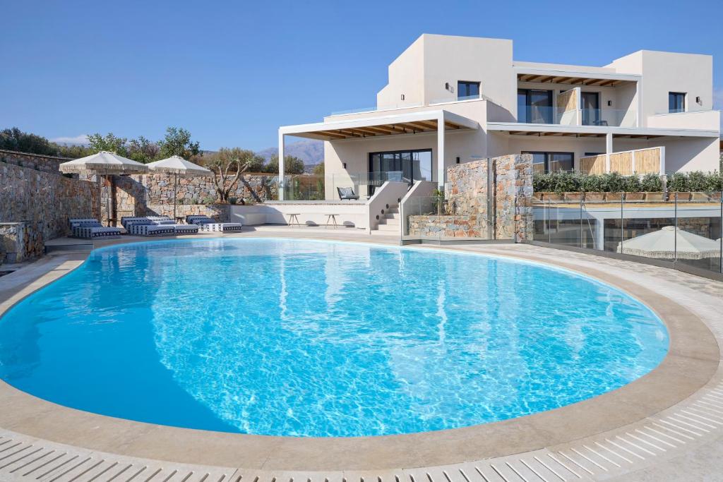 Mirabello Bay Luxury Resort baseins ar saules gultām un balkonu