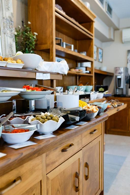 Bufete ar dažādiem ēdieniem un uzkodu traukiem, ievietota koka skapī.